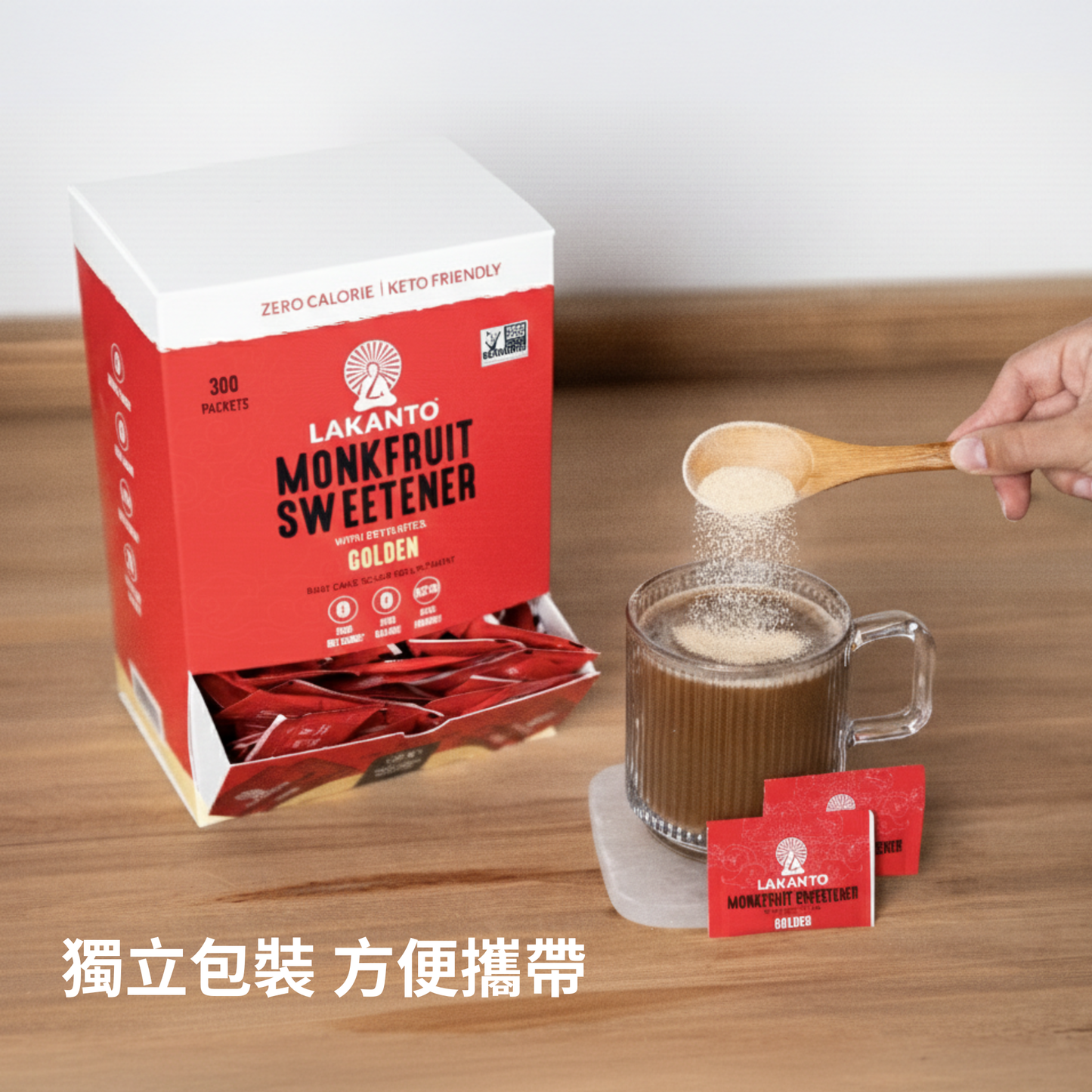Lakanto 羅漢果甜味劑 Golden 獨立小包裝搭配熱咖啡使用情境，木桌上放有 Lakanto Monkfruit Sweetener Golden 紙盒與小包裝，展示加入飲品中使用的實際畫面，適合日常熱飲使用